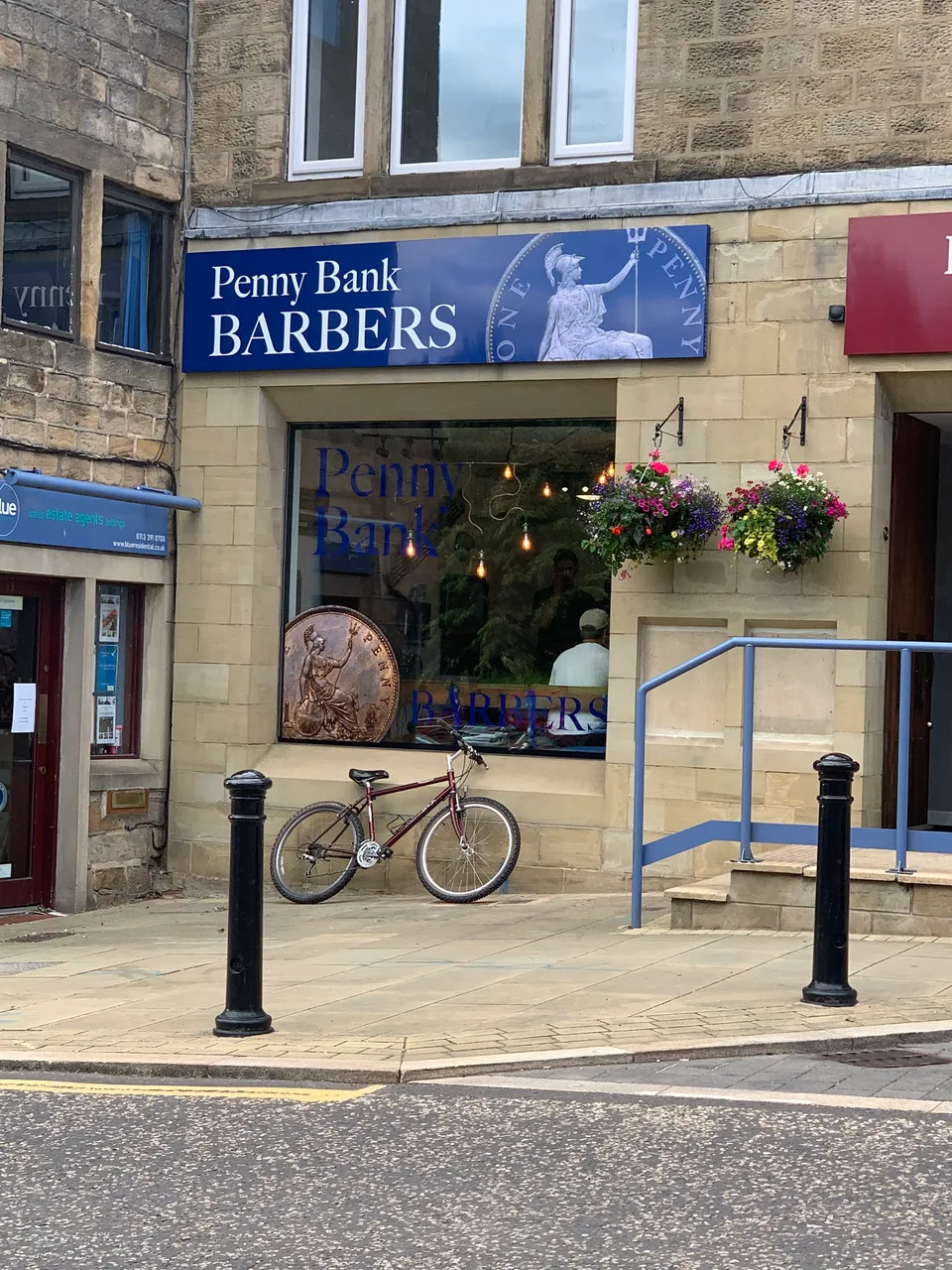 Penny Bank Barbers' blue sign above the shop window on Yeadon High Street