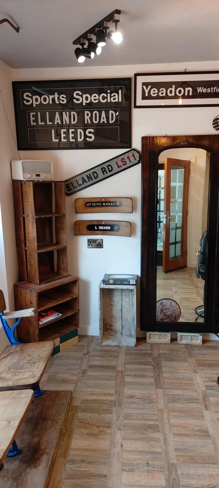 Wooden waiting bench, framed railway signs and a traditional tall mirror at Penny Bank