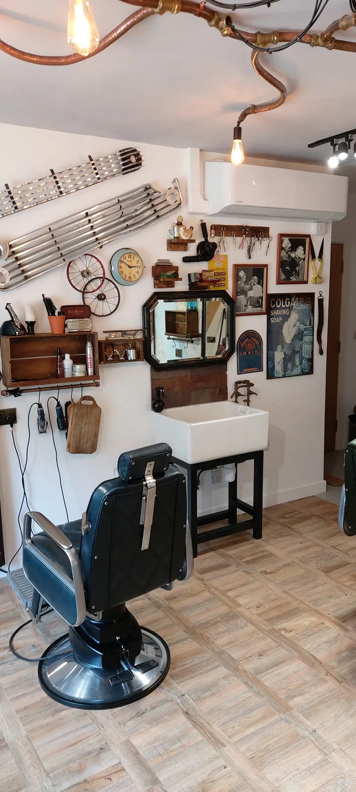 Traditional barber chair and wash basin, framed mirror and timber shelves inside Penny Bank